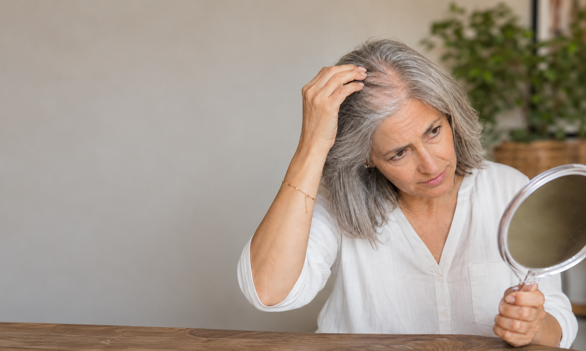 Woman examining her silver hair in a mirror